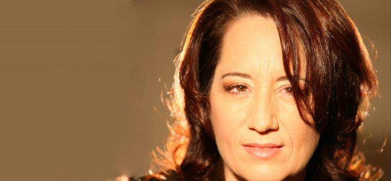 Close-up of a woman with soft lighting and a serene expression.